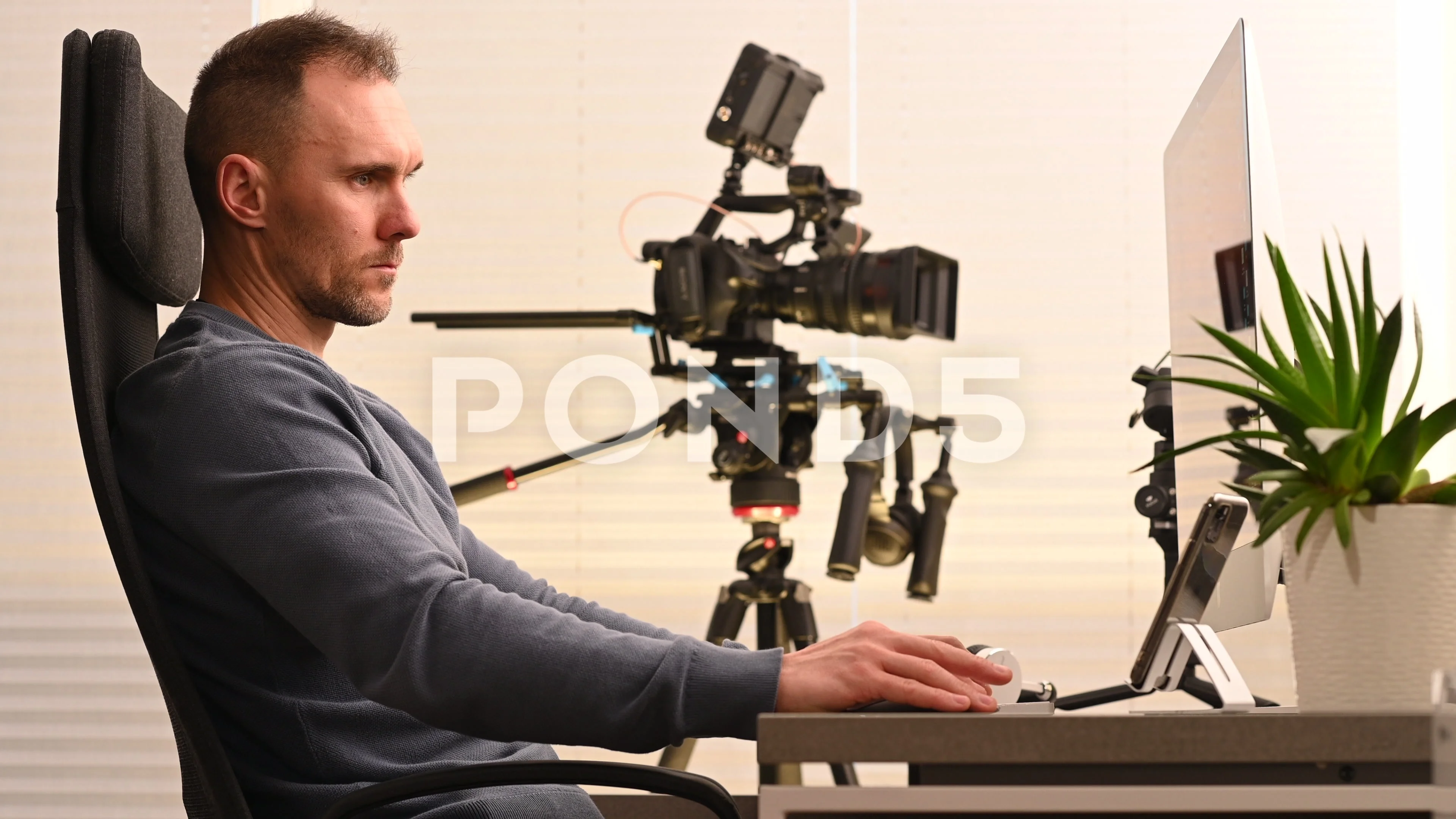 FIlm Post Production Worker In Front of Desktop Computer Editing Video Clips