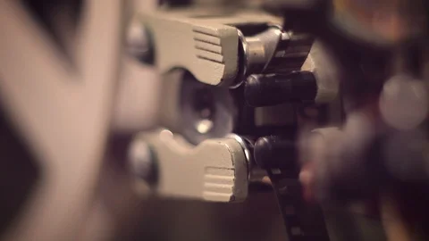 Film projector on a black background with dramatic lighting and selective focus. Видео 97921525