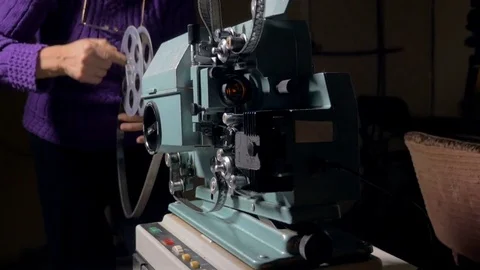 Film projector. Cameraman setting old movie projector Stock Footage