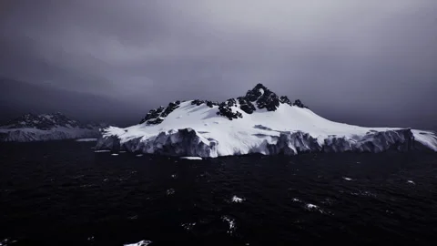 Filmic snow island with dramatic lighting and contrasting sky backdrop Stock Footage 339618797