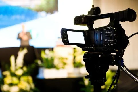 Filming conference with video camera on tripod, camera in foreground Stock-Fotos