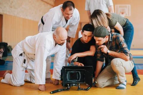 Filming crew watches video materials on the stage Stock Photos