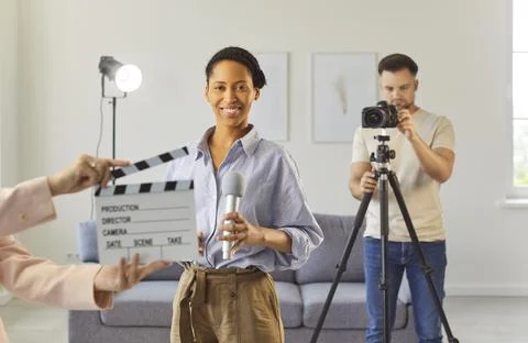 Filming interview or media content in studio, smiling woman holding microphone Stock Photos