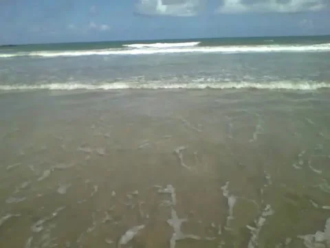 Filming the pretty ocean waves for over 30 seconds at the edge of the beach Stock Footage 163685059