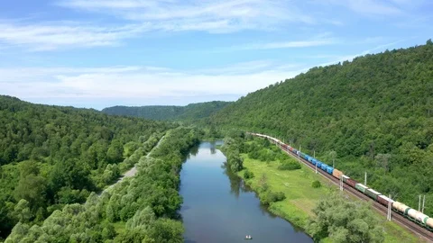 Filming the pursuit of a freight train passing at the foot of a ridge. Stock Footage 119068960