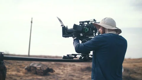 Filming in the steppe. The operator moves the video camera along the slider Stock Footage 221915191