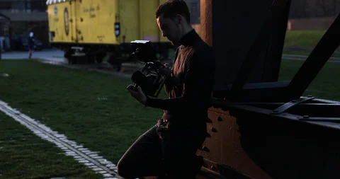 Filmmaker camera handheld on sunset in a big city. People run in background Stock Footage 126862413