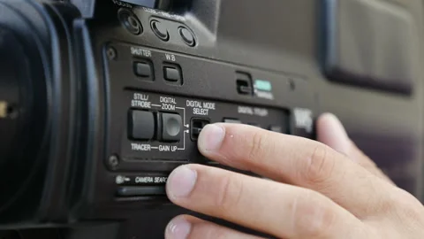 Filmmaker clicks the settings button in professional camera Stock Footage 95232885