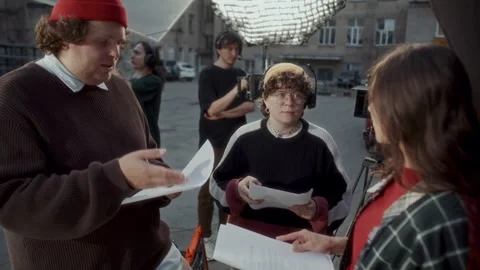 Filmmaker Explaining Script and Directing Actors on Outdoor Movie Set Video stock 336702687