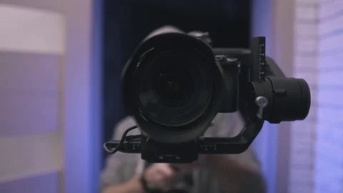 Filmmaker operates handheld gimbal with camera. 4K UHD cinematic panorama. Stock Footage 100267877