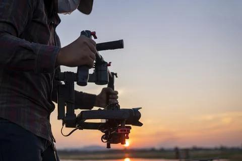 Filmmaker or content creator using stabilizer gimbal camera take video footag Stock Photos