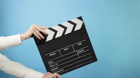 Filmmaking process with a hand holding a clapperboard, setting up a new tak.. Stock Footage 307096688