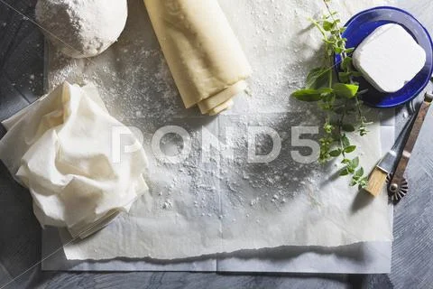 Filo pastry and cheese on baking paper for making burekas Stock Photos
