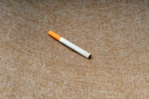 A filter cigarette lies on burlap Stock Photos
