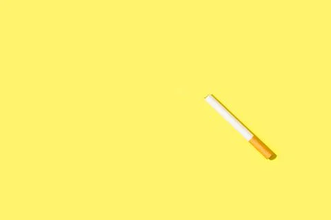 A filter cigarette on a yellow background with copy space Stock Photos