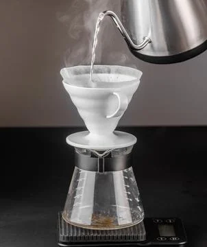 Filter coffee brewing on black background. Pour-over alternative method of .. Stock Photos