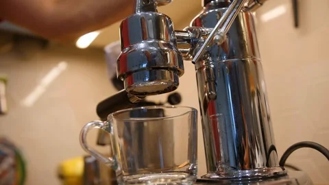 Filter of coffee machine and hot beverage pouring through it unto mug. Low angle Video stock 97494722