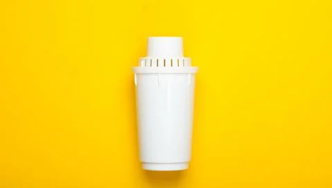 Filter element of water purifier on yellow background. Top view Stock Photos