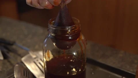 Filtering The Cooked Marijuana Buds With A Fine Mesh Placed In A Jar To Stock Footage 131208418