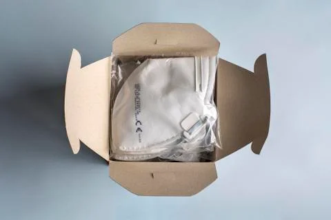 Filtering face mask in packaging. Box full of disposable medical dust masks Stock Photos