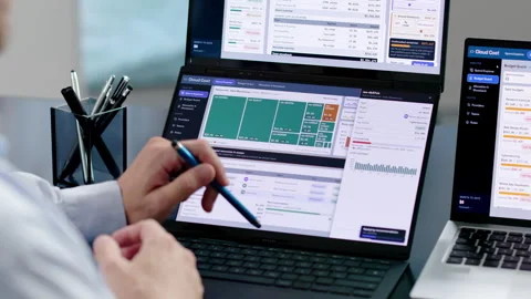 Fin-ops Manager Analyzes Cloud Spend Using Dual Laptops Stock Footage 347284625