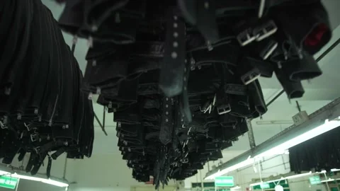 Final black leather jacket hanging in factory Stock Footage 202460452