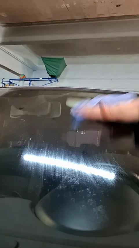 Final cleaning of car windshield after crack restoration process at garage Stock Footage 337325955