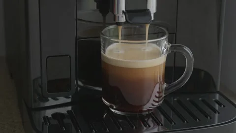 Final drops of espresso dripping into glass cup with thick crema, close up Stock Footage 346453212