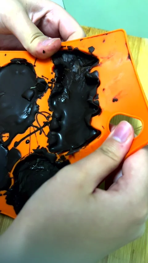 Final moment of Halloween chocolate creation. Child hands carefully release Stock Footage 343478347