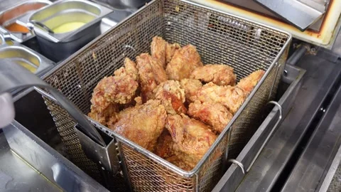 Final moments of deep frying bone-in chicken before lifting from hot oil Stock Footage 340566584
