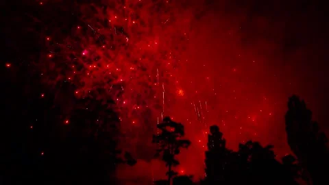 Final part of fireworks. Red glow in smoke from fireworks in night sky Stock Footage 314560295