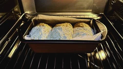 Final proof dough lined with  parchment paper is in Oven Stock Photos