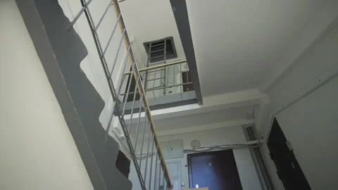 Final staircase level leads towards exit door on rooftop Видео 332269679