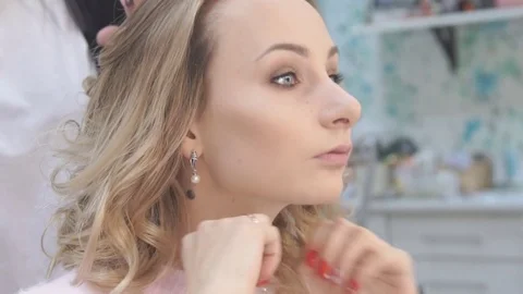 The final styling of curly hair of model by hairdresser in beauty salon Stock Footage 69921527
