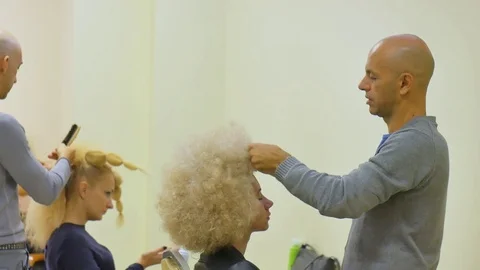 The final styling of curly hair of model by hairdresser in beauty salon Stock Footage 70796556