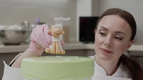 The final touch in decorating the cake, the confectioner carefully puts on the Vídeo Stock 128123517