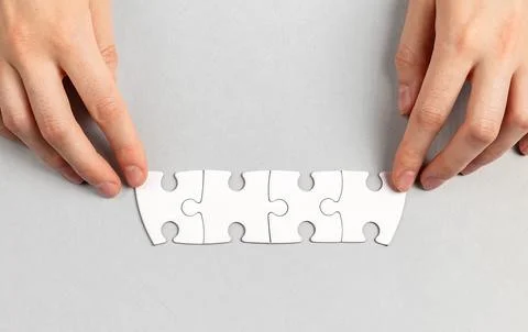 The final touch. Hands placing the missing puzzle piece. Stock Photos