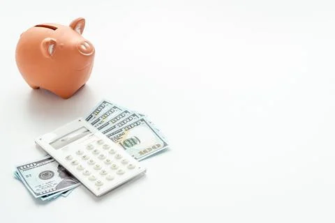 Finance and saving money concept. Piggy bank with cash money and calculator Stock Photos
