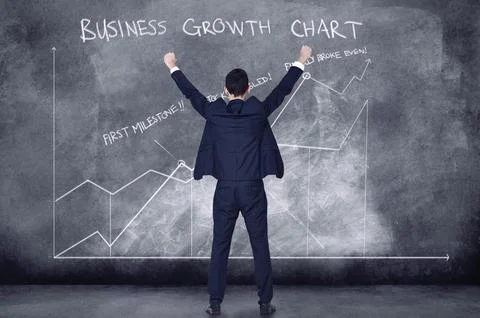 Finance business man cheering in success looking at a cgi graph, chart and data Stock Photos