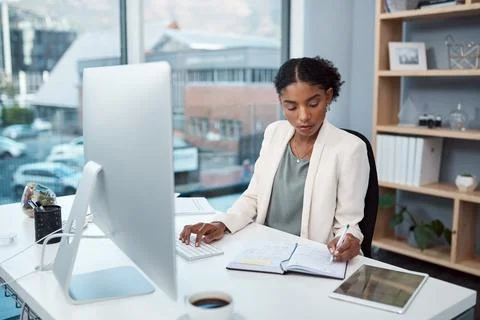 Finance manager writing notes, typing on a computer keyboard and planning to 스톡 사진