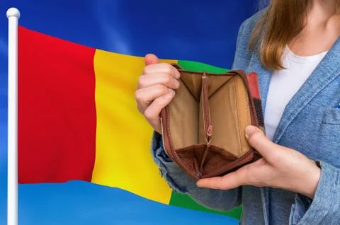 Finance problem in Guinea. Poor person with empty wallet on national flag bac Foto stock