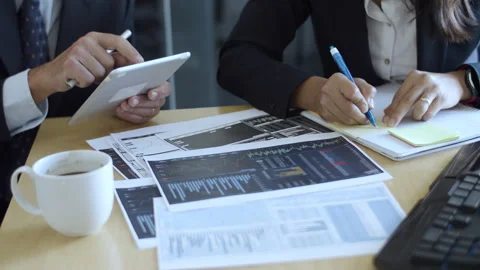 Finance professionals using tablet and writing notes Stock Footage 145415332
