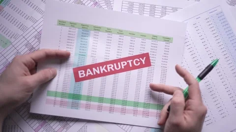 Finance Spreadsheet on a Table With BANKRUPTCY Stamp Over Stock Footage 255991954