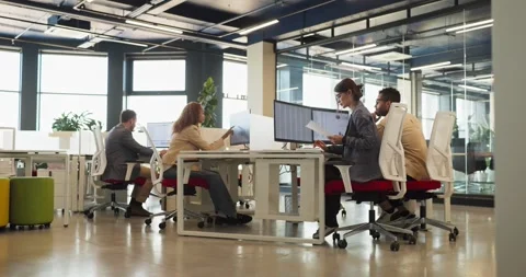 Finance team of analysts collaborating at computers in modern open plan office Stock Footage 341702124