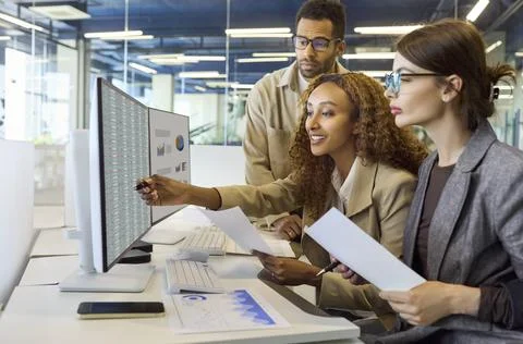 Finance team analyzing data on computer during office meeting and planning Stock Photos