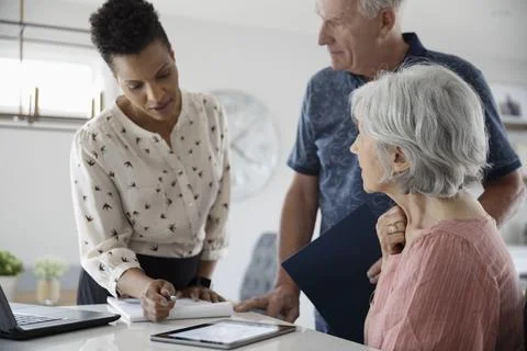 Financial advisor with digital tablet talking to senior couple Stock Photos