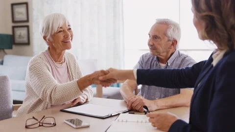Financial advisor shaking hands with senior woman after a deal Stock Footage 157150574