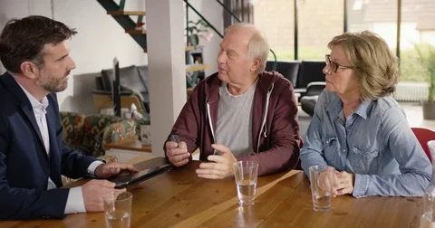 Financial advisor typing data of senior couple in tablet Video stock 82153827