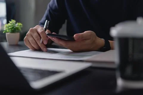Financial analysis with paper document and smartphone in hand, modern busin.. Stock Photos