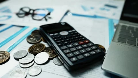 Financial Analysis Workspace with Calculator and Coins, A calculator, coins.. Stock Footage 304960922